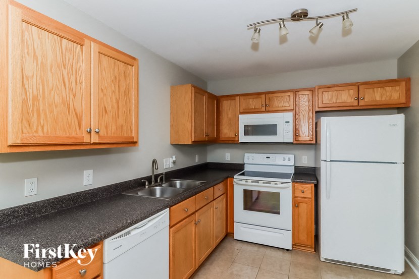 a kitchen with white appliances and wooden cabinets