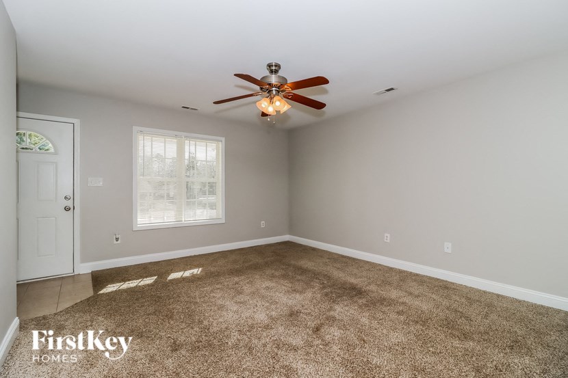 a bedroom with a ceiling fan and a carpet