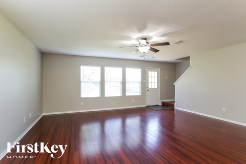 a living room with wood floors and a ceiling fan