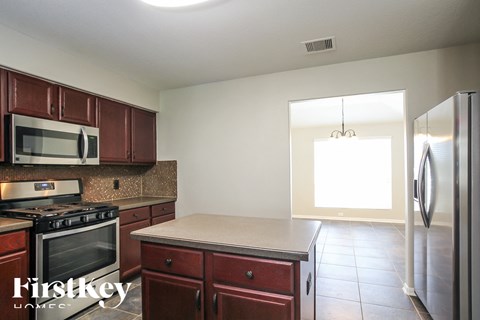 a kitchen with wooden cabinets and stainless steel appliances
