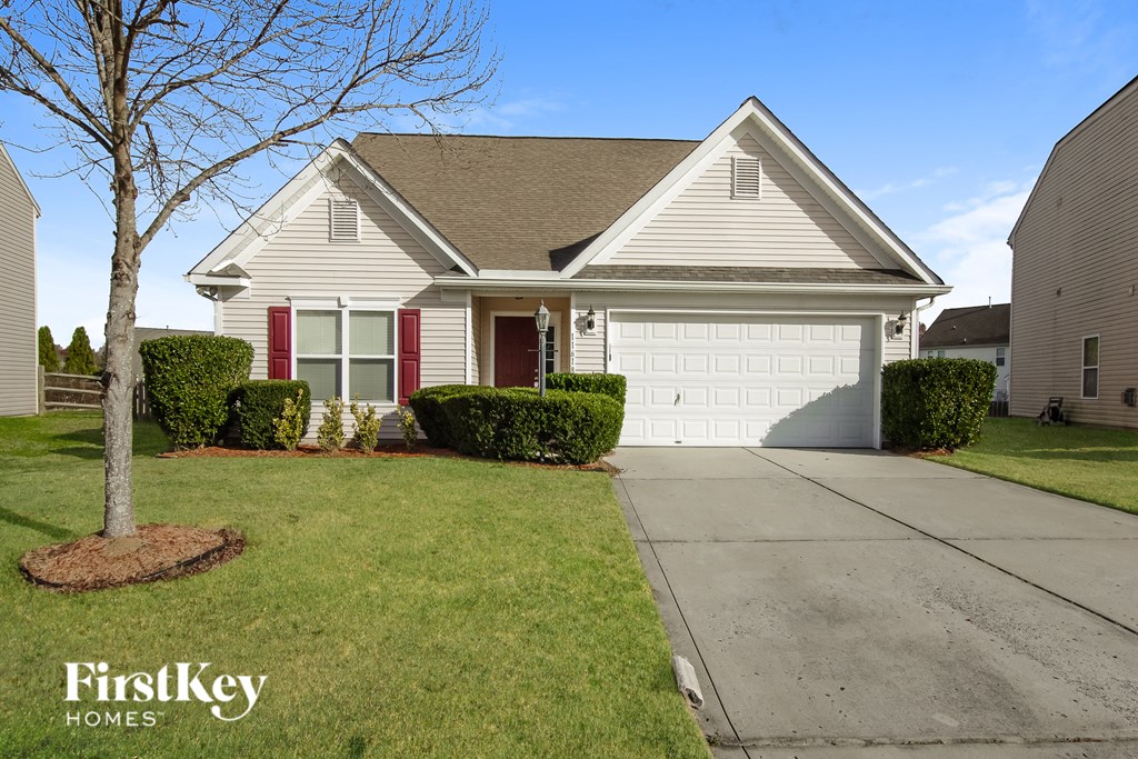 A house with a red door and a tree in front of it.