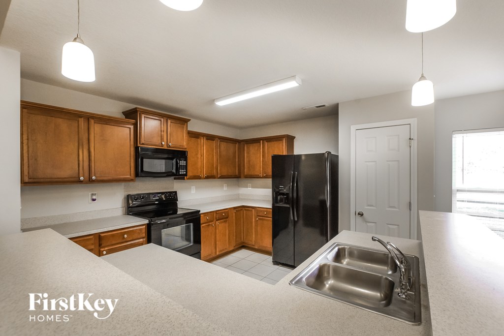 A kitchen with wooden cabinets and black appliances.