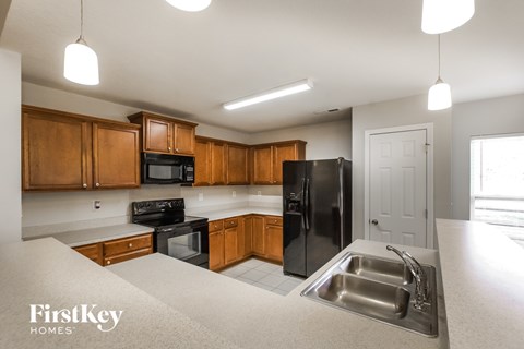 A kitchen with wooden cabinets and black appliances.