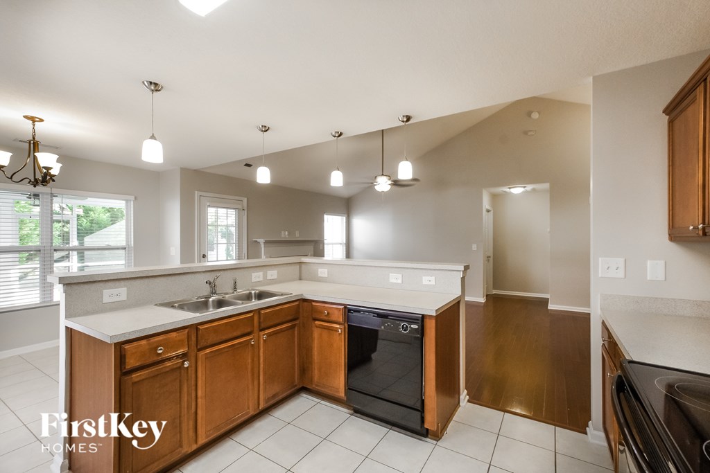 A kitchen with wooden cabinets and a black dishwasher.