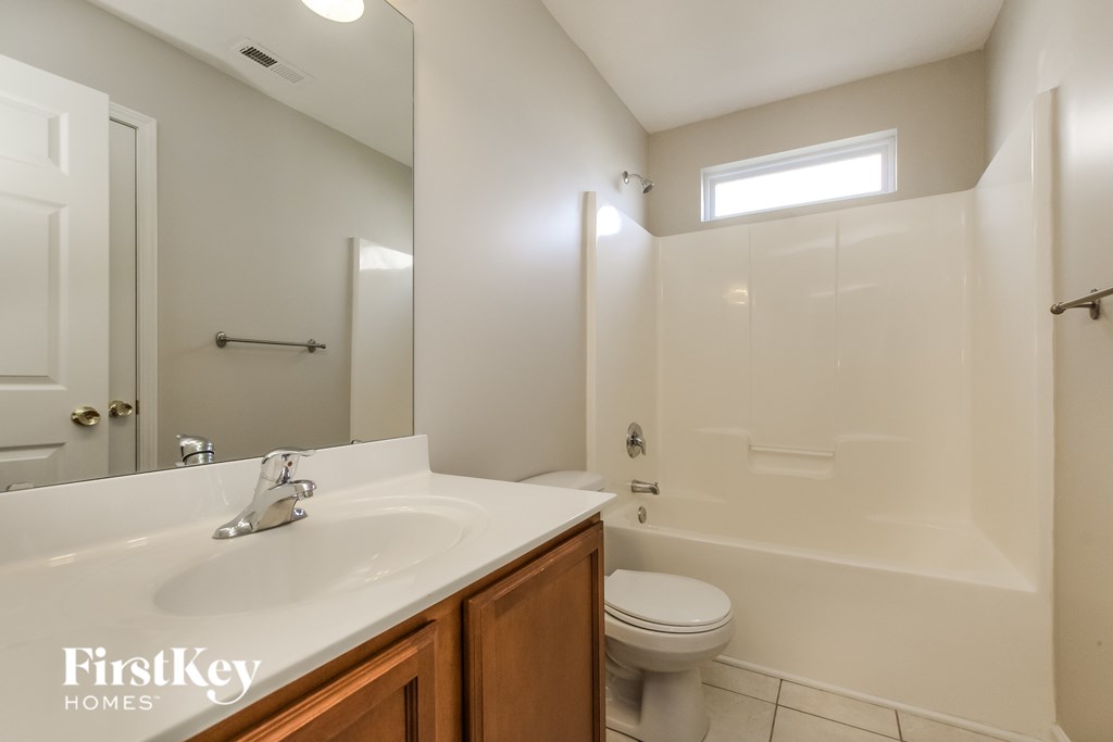 A white bathroom with a sink, toilet and bathtub.