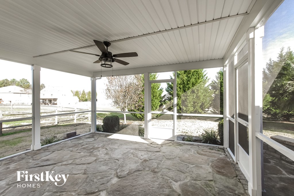 A patio with a ceiling fan and slate flooring.