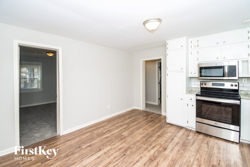 a renovated kitchen with white cabinets and stainless steel appliances