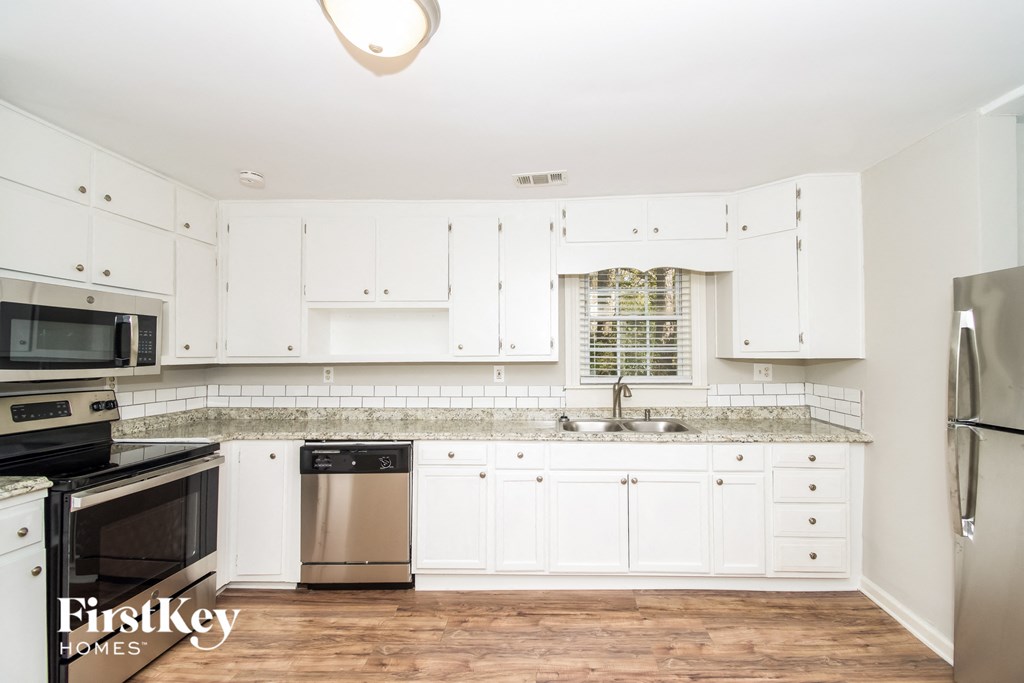 a kitchen with white cabinets and stainless steel appliances