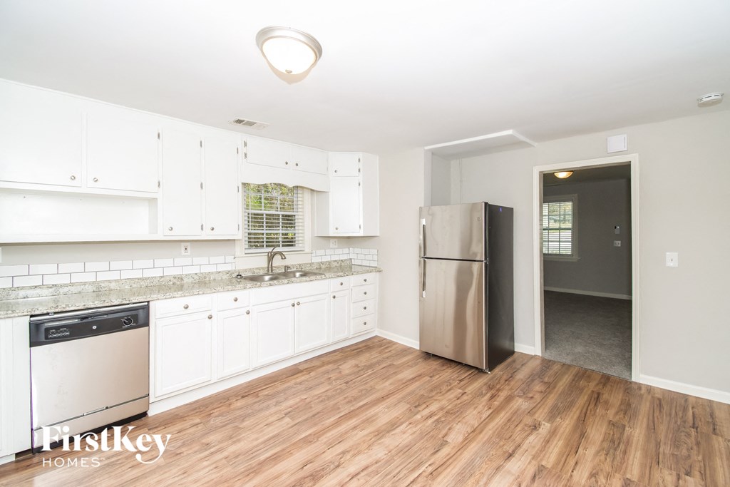 a kitchen with white cabinets and a stainless steel refrigerator
