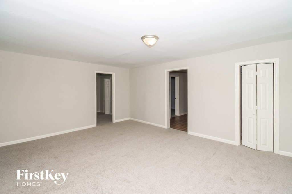 a master bedroom with two doors and a carpeted floor
