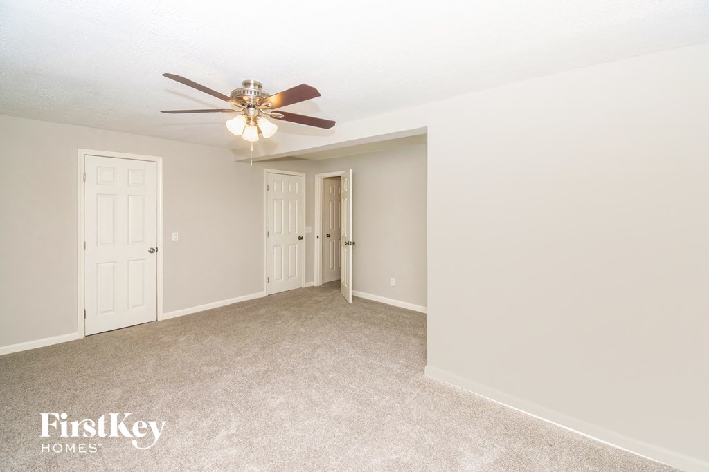 a bedroom with a ceiling fan and a door to a closet