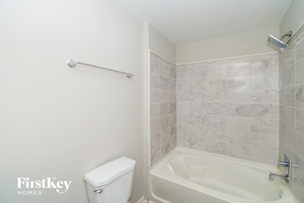a white bathroom with a white toilet and a tub and a sink