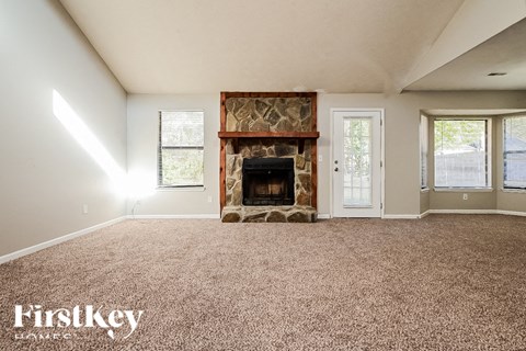 A room with a fireplace and a carpeted floor.