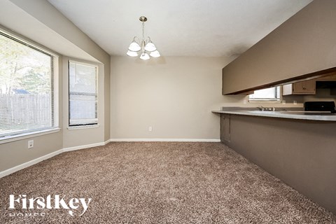 A room with a carpeted floor and a window with blinds.