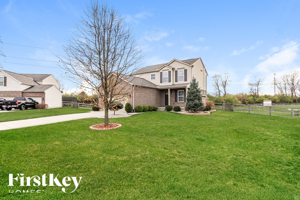 A house with a tree in the front yard.