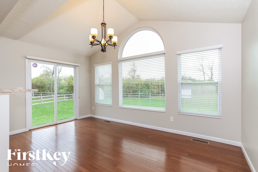 A room with wooden floors and a chandelier hanging from the ceiling.