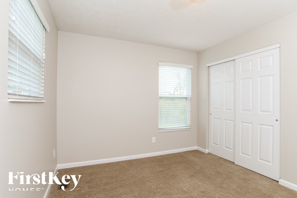 A room with a white door and a window with blinds.
