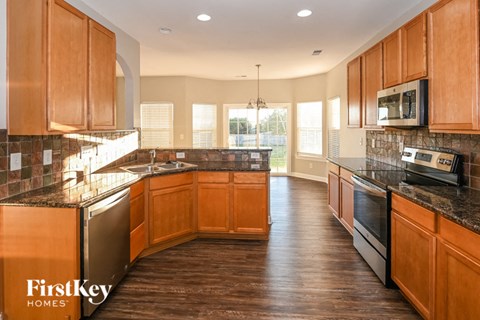 a large kitchen with wooden cabinets and stainless steel appliances