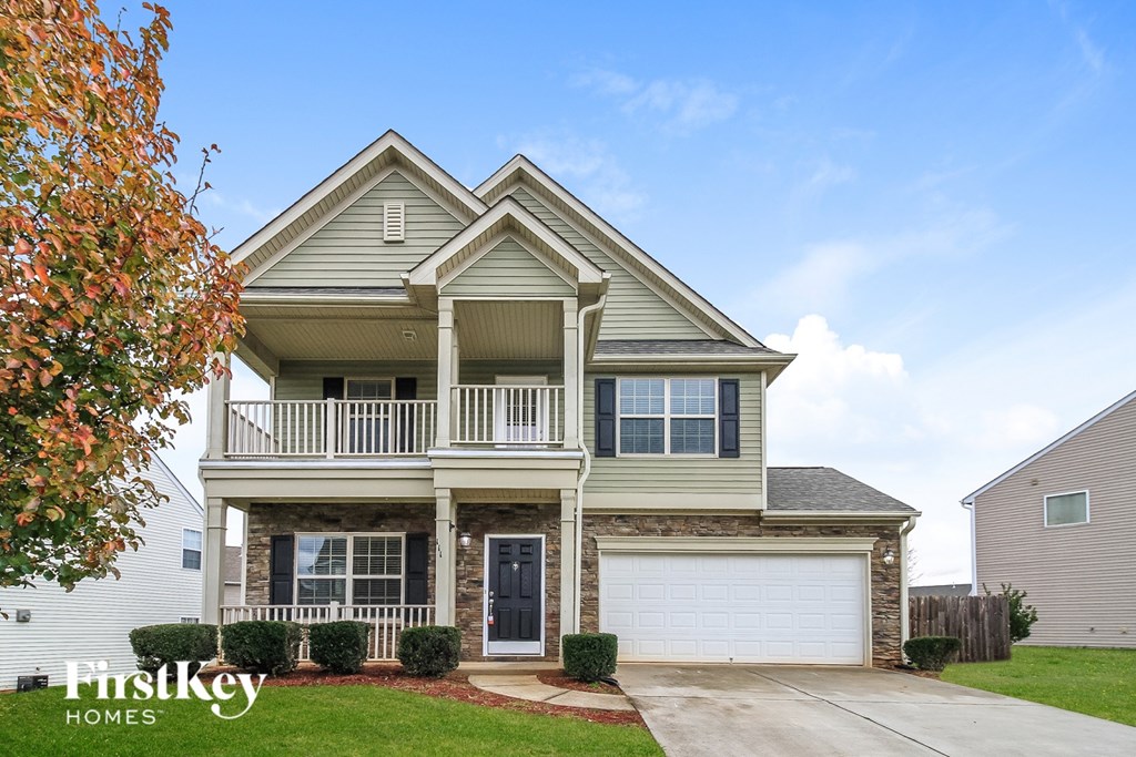 A two-story house with a balcony and a garage.