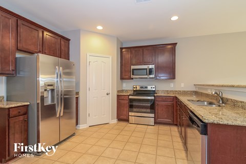 A kitchen with brown cabinets and a refrigerator.