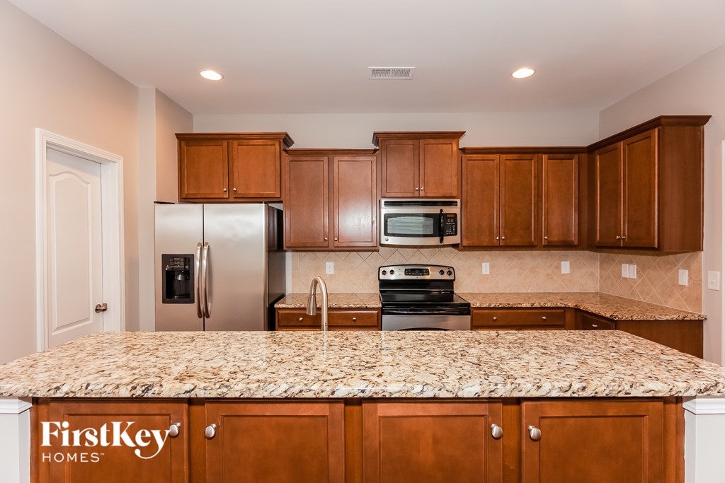 A kitchen with wooden cabinets and a granite countertop.