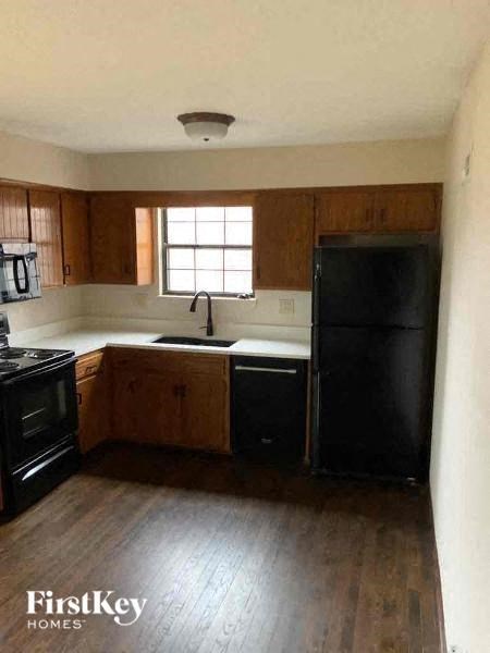a kitchen with a black refrigerator and a sink