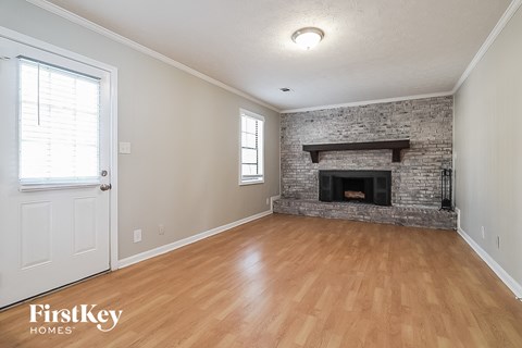 A room with a fireplace and wooden floors.