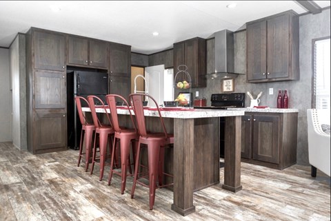 a kitchen with a large island with red chairs