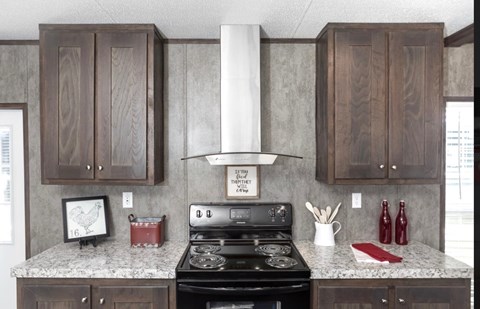 a kitchen with wood cabinets and black appliances and a granite counter top