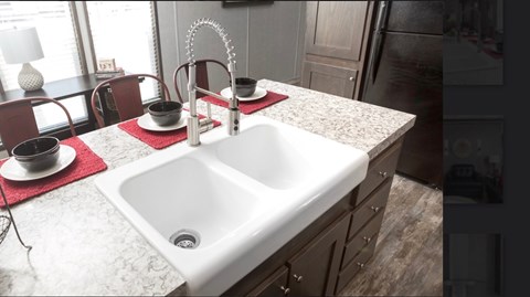a white sink in a kitchen with a marble counter top