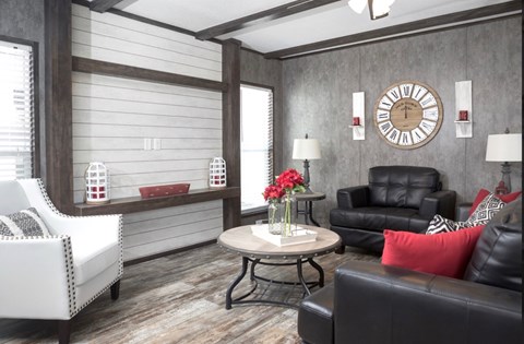 a living room with leather furniture and a clock on the wall