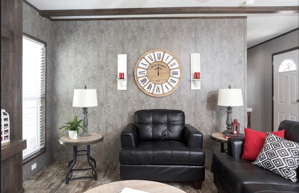 a living room with leather furniture and a large clock on the wall