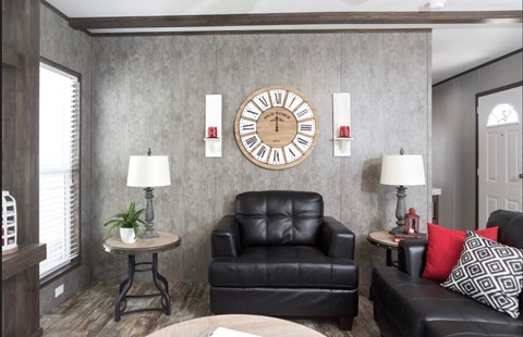 a living room with leather furniture and a large clock on the wall