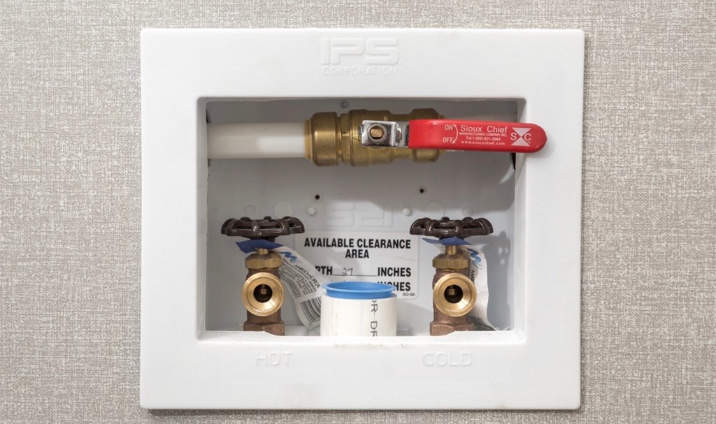 a white box with two valves and a red valve handle