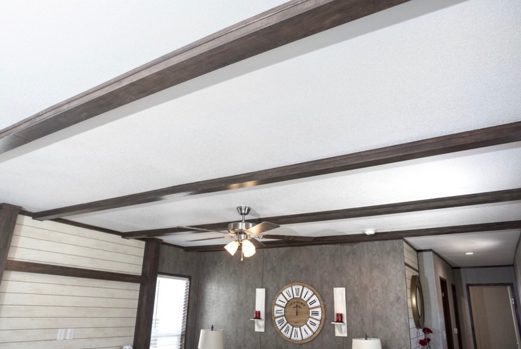 a living room with a ceiling fan and a clock on the wall