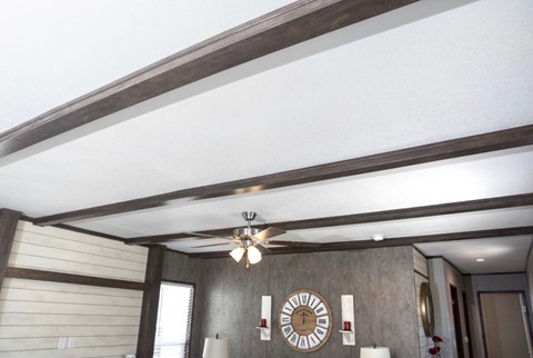 a living room with a ceiling fan and a clock on the wall