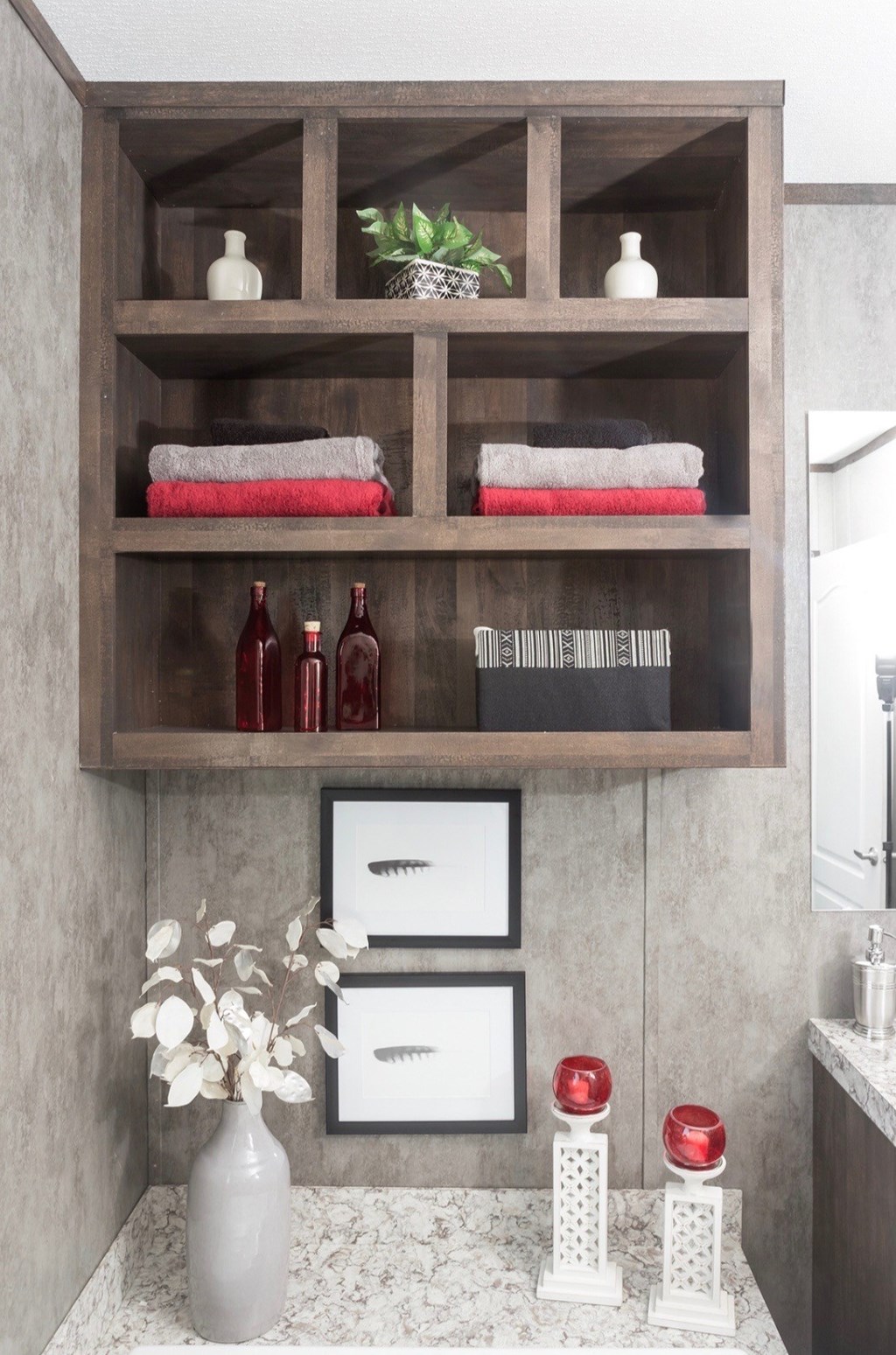 a bathroom shelf with towels and bottles on it