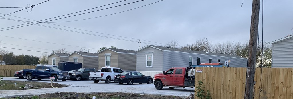 a group of cars parked in front of a row of houses