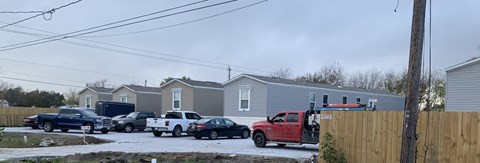 a group of cars parked in front of a row of houses