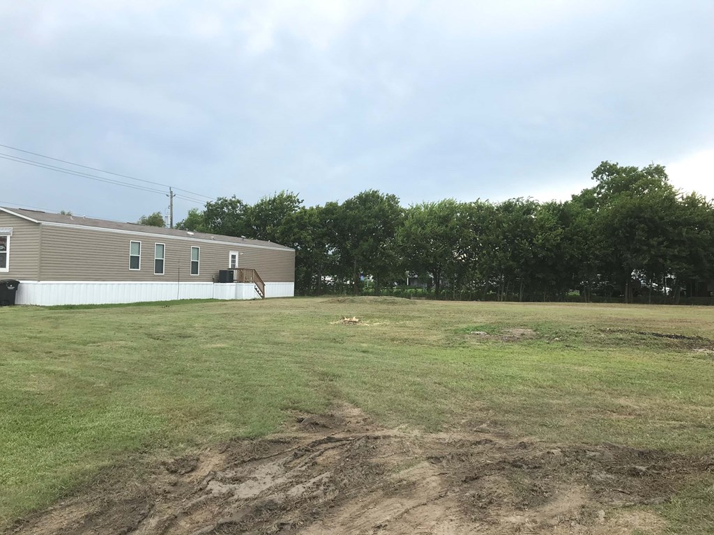 a small building in a field next to a house