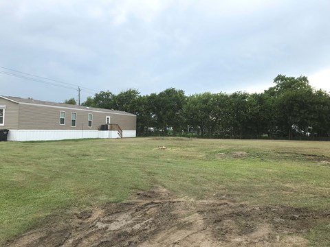 a small building in a field next to a house
