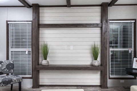 a living room with a white wall and two shelves with plants