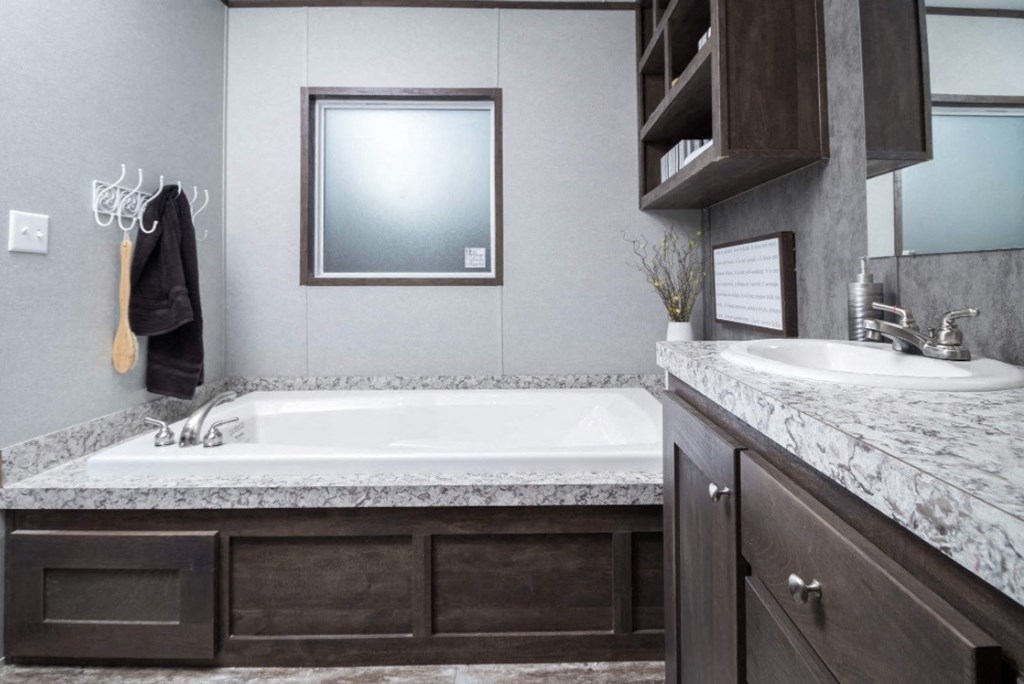 a bathroom with a tub and a sink and a mirror