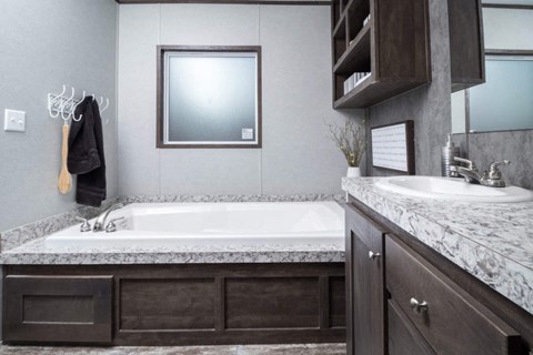 a bathroom with a tub and a sink and a mirror