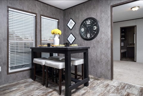 a dining room with a table and a clock on the wall