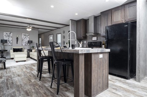 a kitchen with a center island and black appliances