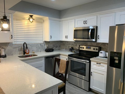 a kitchen with stainless steel appliances and white cabinets