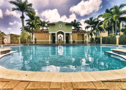 A pool in front of a building with a fence around it.
