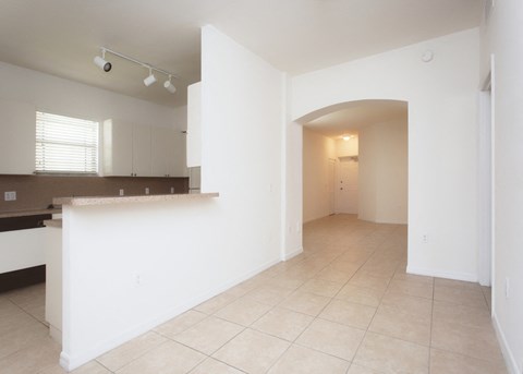 A kitchen with white cabinets and a countertop is shown.