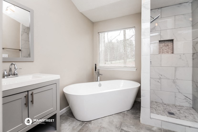 a bathroom with a tub and a sink and a shower